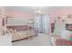 Light-filled bedroom showcasing a white bunk bed, a whimsical chandelier, and coordinating pastel pink decor for a delightful space at 14931 W Black Wolf Run Dr, Carmel, IN 46033