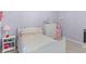 Serene lavender bedroom featuring a comfortable bed, a dresser, and a fun mini-fridge, creating a playful and inviting space at 14931 W Black Wolf Run Dr, Carmel, IN 46033