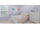 Cozy lavender bedroom featuring a comfortable bed, a dresser, and a window with blinds, creating a serene and inviting space at 14931 W Black Wolf Run Dr, Carmel, IN 46033