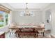 Formal dining area with modern chandelier over wood table, seating for eight, and decorative window at 14931 W Black Wolf Run Dr, Carmel, IN 46033