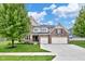 Beautiful two-story brick home with attached two car garage, manicured lawn, and mature shade tree at 14931 W Black Wolf Run Dr, Carmel, IN 46033