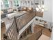 Sunlit living area with custom built-ins, stylish furnishings, and a staircase with wrought iron railing detail at 14931 W Black Wolf Run Dr, Carmel, IN 46033