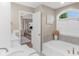 Elegant bathroom with soaking tub, neutral walls, and an open doorway to main bedroom at 14931 W Black Wolf Run Dr, Carmel, IN 46033