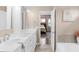 Elegant bathroom with dual sink vanity, soaking tub, and view to main bedroom at 14931 W Black Wolf Run Dr, Carmel, IN 46033