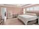 Bright main bedroom with pink walls, hardwood floors, and lots of natural light at 14931 W Black Wolf Run Dr, Carmel, IN 46033