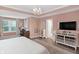 Spacious bedroom boasts a modern chandelier, hardwood floors, and stylish decor at 14931 W Black Wolf Run Dr, Carmel, IN 46033
