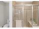 Tiled shower with glass enclosure and bench seating in neutral bathroom at 14931 W Black Wolf Run Dr, Carmel, IN 46033
