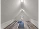 Finished attic features modern lighting, wood floor, small window and fitness equipment at 1627 Pleasant St, Indianapolis, IN 46203