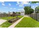 Expansive backyard featuring a lush lawn, playset, garden beds, and detached garage at 1627 Pleasant St, Indianapolis, IN 46203