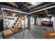Unfinished basement with exposed ceiling, painted white block walls, and a set of wooden stairs at 1627 Pleasant St, Indianapolis, IN 46203