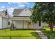 Exterior shot of a house featuring a covered front porch, bright yellow door and green lawn at 1627 Pleasant St, Indianapolis, IN 46203