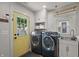 Bright laundry room with modern washer and dryer, utility sink, and storage cabinets at 1627 Pleasant St, Indianapolis, IN 46203