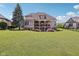 Large backyard with a sprawling green lawn, framed by a two-story home with brick accents at 16332 Valhalla Dr, Noblesville, IN 46060