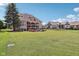 Expansive backyard with a large green lawn, a two-story brick home and an adjacent building at 16332 Valhalla Dr, Noblesville, IN 46060