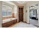 Elegant bathroom with a luxurious soaking tub, walk-in shower, and an archway to the main bedroom at 16332 Valhalla Dr, Noblesville, IN 46060