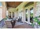 Relaxing covered patio with brick arches, stone walls, ceiling fan and outdoor furniture at 16332 Valhalla Dr, Noblesville, IN 46060
