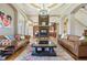Inviting living room with hardwood floors, stone fireplace, custom lighting, and comfortable leather sofas at 16332 Valhalla Dr, Noblesville, IN 46060