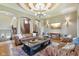 Spacious living room with coffered ceilings, hardwood floors, custom lighting, and comfortable seating arrangements at 16332 Valhalla Dr, Noblesville, IN 46060