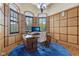 Home office featuring custom wood paneling, hardwood floors, a blue rug, and an executive desk at 16332 Valhalla Dr, Noblesville, IN 46060