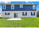 Two-story home featuring a blue-sided upper level and a white brick lower level, complemented by a grassy backyard at 1704 Beach St, Greenwood, IN 46143