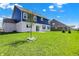 A manicured lawn surrounds the back of this two-story home with a brick and blue siding exterior at 1704 Beach St, Greenwood, IN 46143