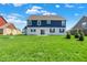 The rear view of this two-story home boasts a white brick lower level and blue siding, with a well-maintained green lawn at 1704 Beach St, Greenwood, IN 46143