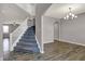 Inviting foyer featuring a staircase, hardwood floors, and an elegant chandelier, perfect for welcoming guests at 1704 Beach St, Greenwood, IN 46143