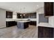 Spacious kitchen featuring dark wood cabinets, white backsplash, and a center island with white countertop at 1704 Beach St, Greenwood, IN 46143