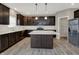A spacious kitchen features dark wood cabinets, stainless appliances and large island with pendant lights at 1704 Beach St, Greenwood, IN 46143