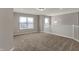 Open loft area featuring large windows, soft carpeting, and modern light fixture at 1704 Beach St, Greenwood, IN 46143