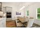Elegant dining area featuring a stylish light fixture, a rustic table and bright natural light at 19257 Red Willow Ln, Noblesville, IN 46062