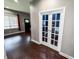 Hallway with hardwood floors, white trim, and French doors leading to office space at 201 N Tacoma Ave, Indianapolis, IN 46201