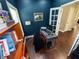 Home office with navy walls, a desk setup, bookshelf, and French doors at 201 N Tacoma Ave, Indianapolis, IN 46201