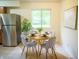 Cozy dining area featuring a round table, seating for four, and stainless steel refrigerator at 21 Roderick Ct, Beech Grove, IN 46107