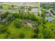 Overhead image of a luxury home surrounded by lush landscaping, a serene pond, and other well-maintained properties at 2411 N County Road 500 W, Muncie, IN 47304