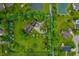 Aerial view of estate with long driveway, mature trees, lush lawn, and private pond at 2411 N County Road 500 W, Muncie, IN 47304