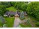 Aerial view of a sprawling single-Gathering home with mature trees, a large driveway, and a basketball hoop at 2411 N County Road 500 W, Muncie, IN 47304