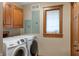 The laundry room has a washer and dryer, a window, and cabinets for storage at 2411 N County Road 500 W, Muncie, IN 47304