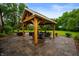 Outdoor patio with custom timber pergola, stone pavers, and multiple seating areas at 2411 N County Road 500 W, Muncie, IN 47304