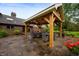 Outdoor patio with custom timber pergola, stone pavers, and multiple seating areas at 2411 N County Road 500 W, Muncie, IN 47304