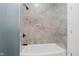 Close-up of a tiled shower and tub with bronze fixtures in an updated bathroom at 2429 N Centennial St, Indianapolis, IN 46222