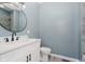 Bathroom featuring white vanity with granite countertop and large round mirror at 2429 N Centennial St, Indianapolis, IN 46222