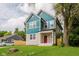 Stylish home with stone accents, unique turquoise siding, and a well-maintained lawn at 2429 N Centennial St, Indianapolis, IN 46222