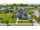 Stunning aerial view of a large home with manicured lawn, landscaping, and neighborhood pond at 2485 Alexandra Dr, Carmel, IN 46074