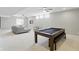 Finished basement with a large pool table and lounge area with comfortable seating at 2485 Alexandra Dr, Carmel, IN 46074