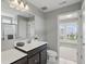 Bright bathroom with dark wood vanity, large mirror, and view of the neighborhood through the window at 2485 Alexandra Dr, Carmel, IN 46074