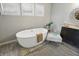 Modern bathroom highlighting a standalone tub, charming decor, and natural light from large windows at 2485 Alexandra Dr, Carmel, IN 46074