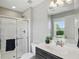 Well-lit bathroom with a glass-enclosed shower, vanity, and a window offering a view of the outdoors at 2485 Alexandra Dr, Carmel, IN 46074