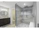 Bathroom showcasing a glass shower with a seat, gray tiling, and a vanity with a decorative mirror at 2485 Alexandra Dr, Carmel, IN 46074