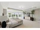 Spacious main bedroom featuring neutral tones, carpet, tray ceiling, sitting area, and large windows overlooking neighborhood at 2485 Alexandra Dr, Carmel, IN 46074